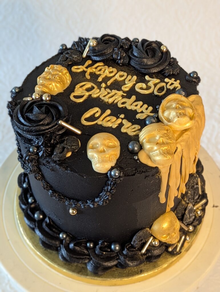 skull5 Image shows a black cake with gold accents including skulls and a gold wax drip